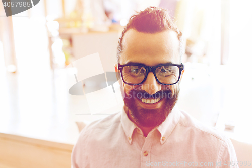 Image of smiling man with eyeglasses and beard at office