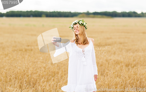 Image of happy young woman taking selfie by smartphone