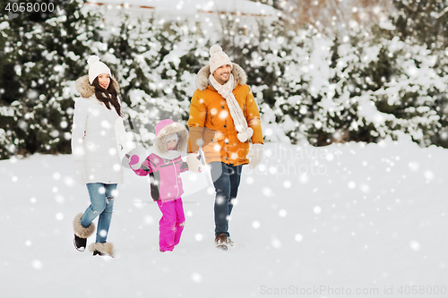 Image of happy family in winter clothes walking outdoors
