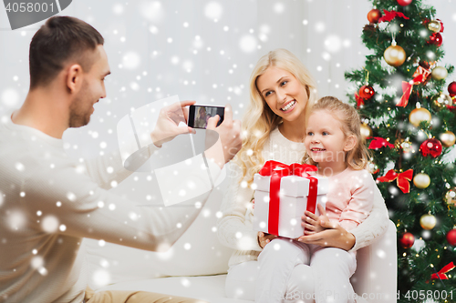 Image of family taking picture with smartphone at christmas