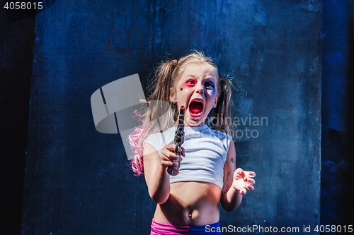 Image of Little girl pointing in toy gun