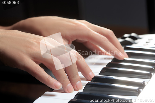 Image of Girl\'s hands on the keyboard of the piano