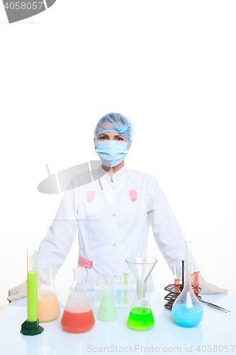 Image of Woman chemist and chemicals in flasks