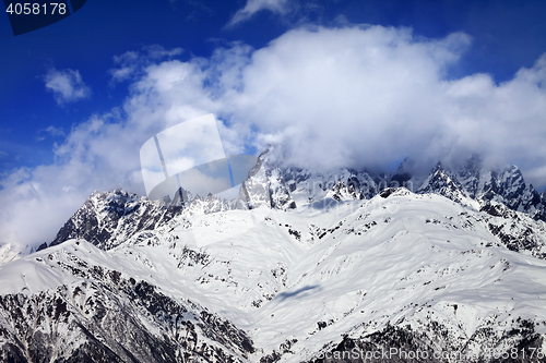 Image of Snow mountains in fog at sun winter day