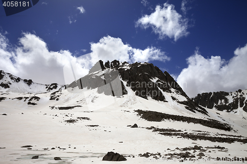 Image of Frozen mountain lake covered with snow at sun spring day