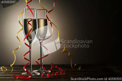 Image of Two champagne glasses with decorative yellow and red ribbons