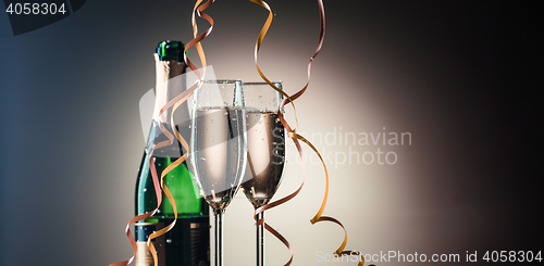 Image of Bottle of champagne and two filled glasses. Festive composition