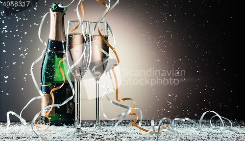 Image of Two glasses with sparkling champagne and classic green bottle