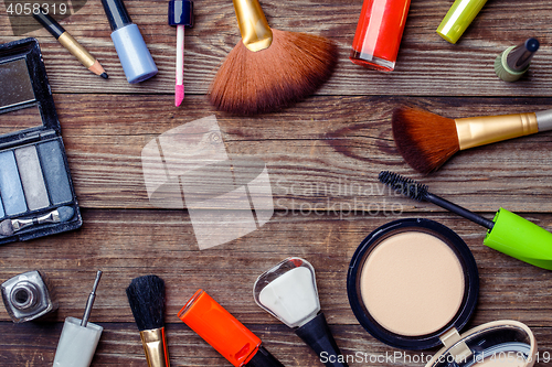 Image of Various make-up products laid on wooden table. Copy space