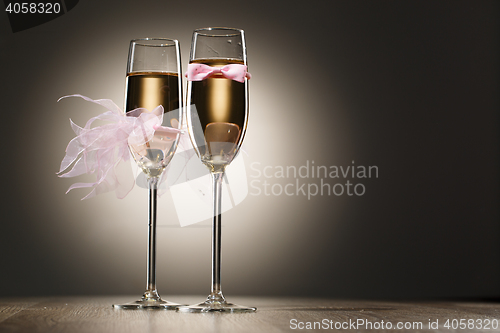 Image of Champagne glasses decorated pink grooms bow-tie and brides veil