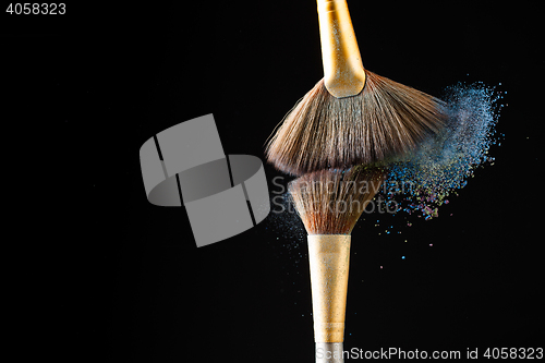 Image of Make-up brushes with powder isolated on black background