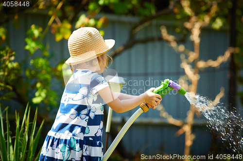 Image of Little happy girl watering garden