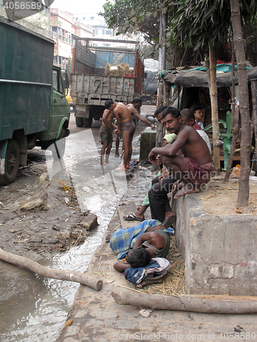 Image of Streets of Kolkata. Indian people wash themselves on street 