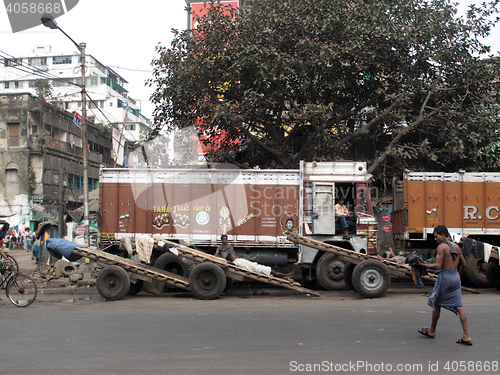 Image of Streets of Kolkata. Trucks and carts wait for customers to transport their cargo