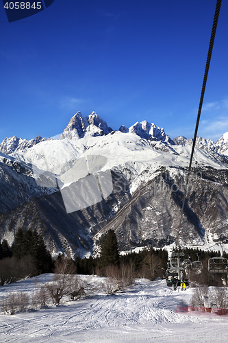 Image of Chair-lift at ski resort and Mount Ushba in sun day