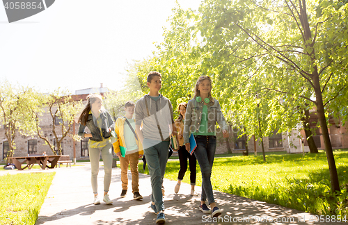 Image of group of happy teenage students walking outdoors