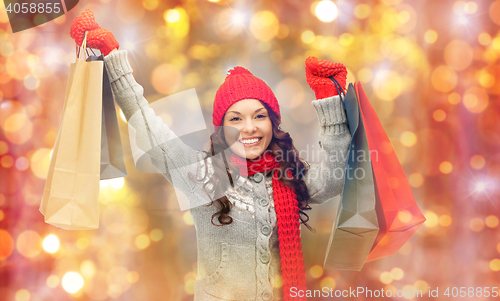 Image of happy woman in winter clothes with shopping bags