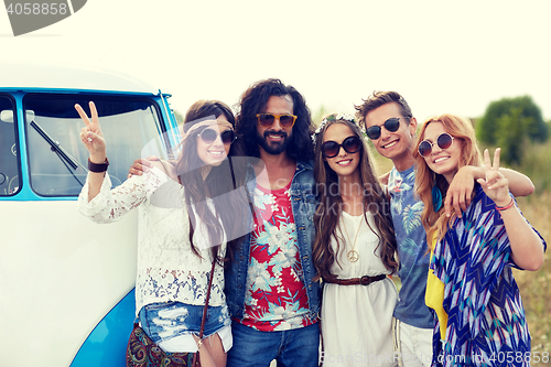 Image of smiling young hippie friends over minivan car