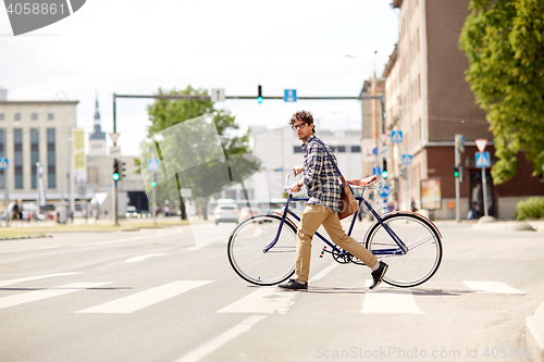 Image of young man with fixed gear bicycle on crosswalk