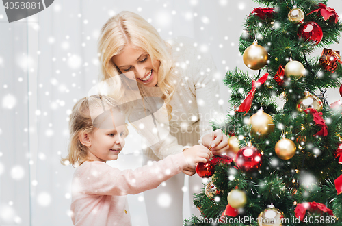 Image of happy family decorating christmas tree at home