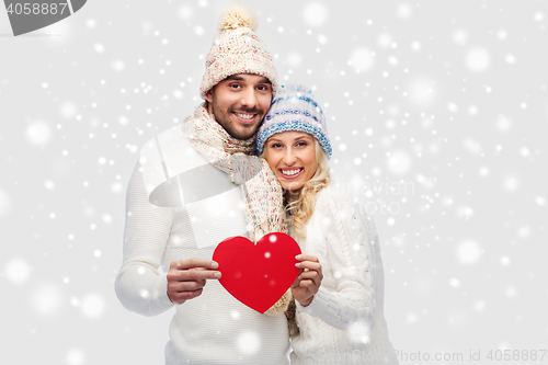 Image of smiling couple in winter clothes with red hearts