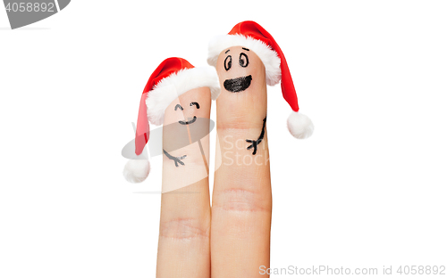 Image of close up of two fingers with smiley and santa hats