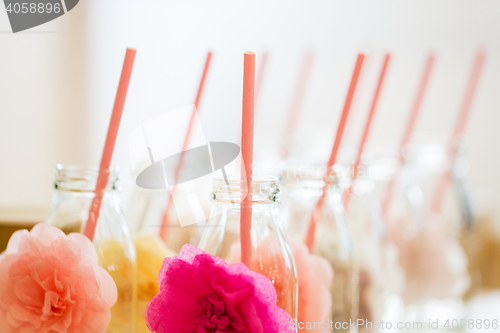 Image of close up of glass bottles for drinks with straws