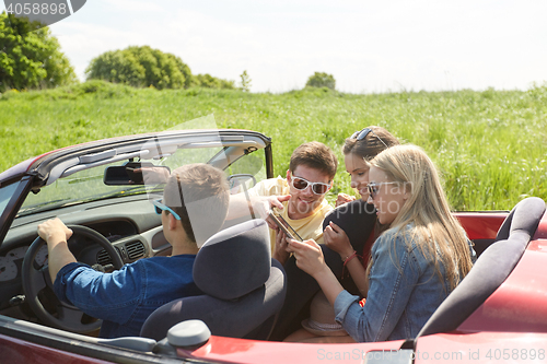 Image of friends with tablet pc driving in cabriolet car