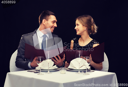 Image of smiling couple with menus at restaurant