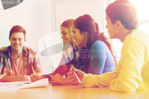 Image of group of smiling students with blueprint