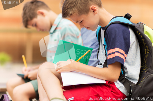 Image of elementary school students writing to notebooks