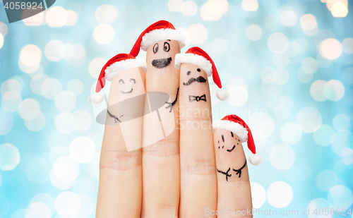 Image of close up of hand with four fingers in santa hats