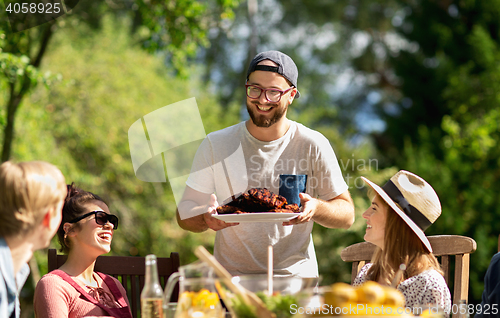 Image of happy friends having dinner at summer garden party