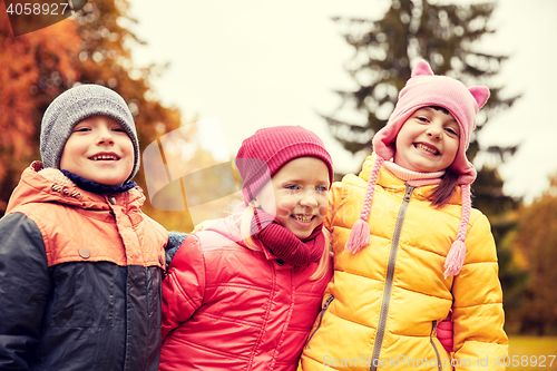 Image of group of happy children hugging in autumn park