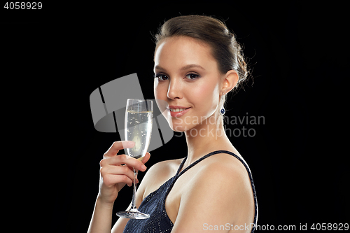 Image of smiling asian woman drinking champagne at party