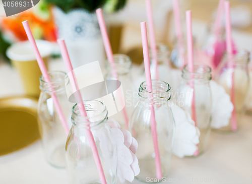 Image of close up of glass bottles for drinks with straws