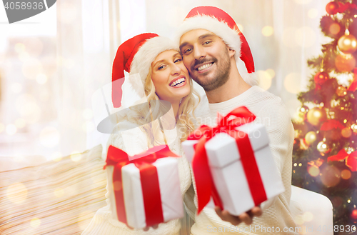 Image of happy couple at home with christmas gift boxes