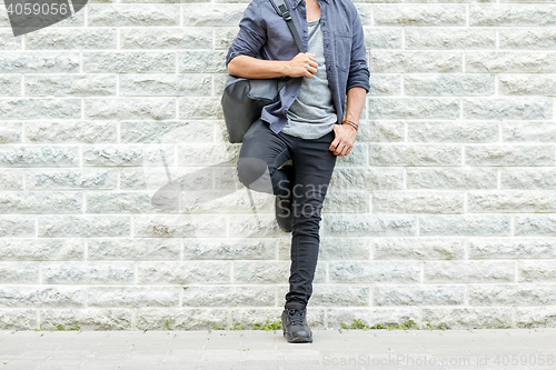 Image of close up of man with backpack standing at wall