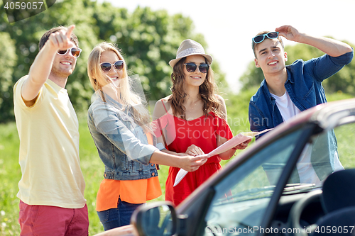 Image of happy friends driving in cabriolet car