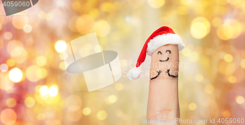 Image of close up of one finger in santa hat over lights