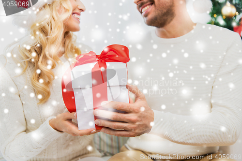 Image of close up of couple with christmas gift at home