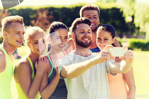 Image of happy friends taking selfie with smartphone