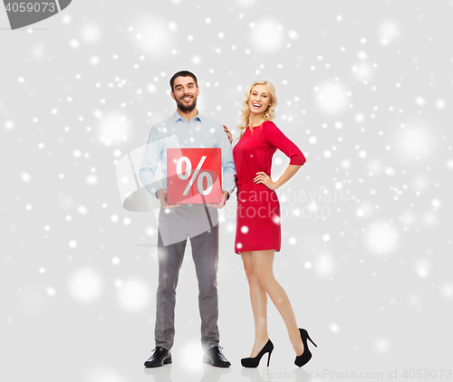 Image of happy couple with red sale sign over snow