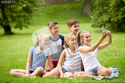 Image of happy kids or friends taking selfie in summer park