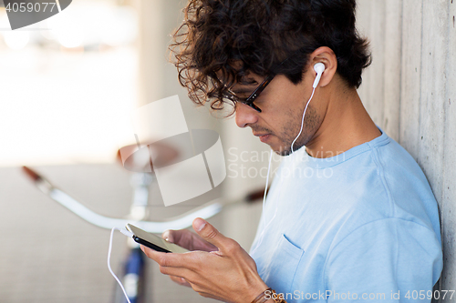 Image of man with smartphon, earphones and bicycle