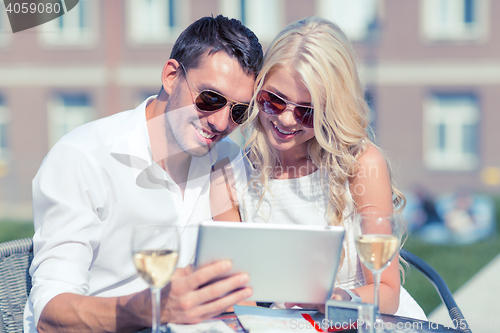 Image of couple looking at tablet pc in cafe