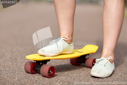 Image of close up of female feet riding short skateboard