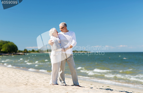 Image of happy senior couple holding hands on summer beach