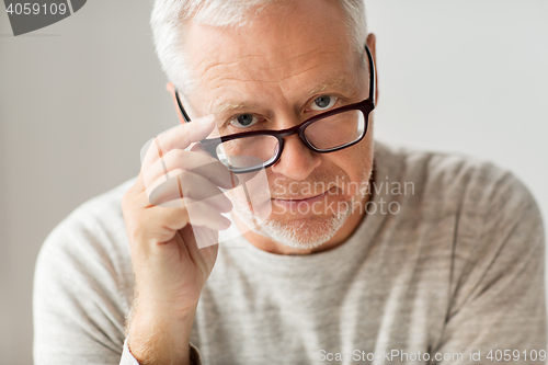 Image of close up of senior man in glasses thinking