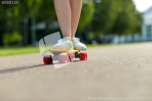 Image of close up of female feet riding short skateboard